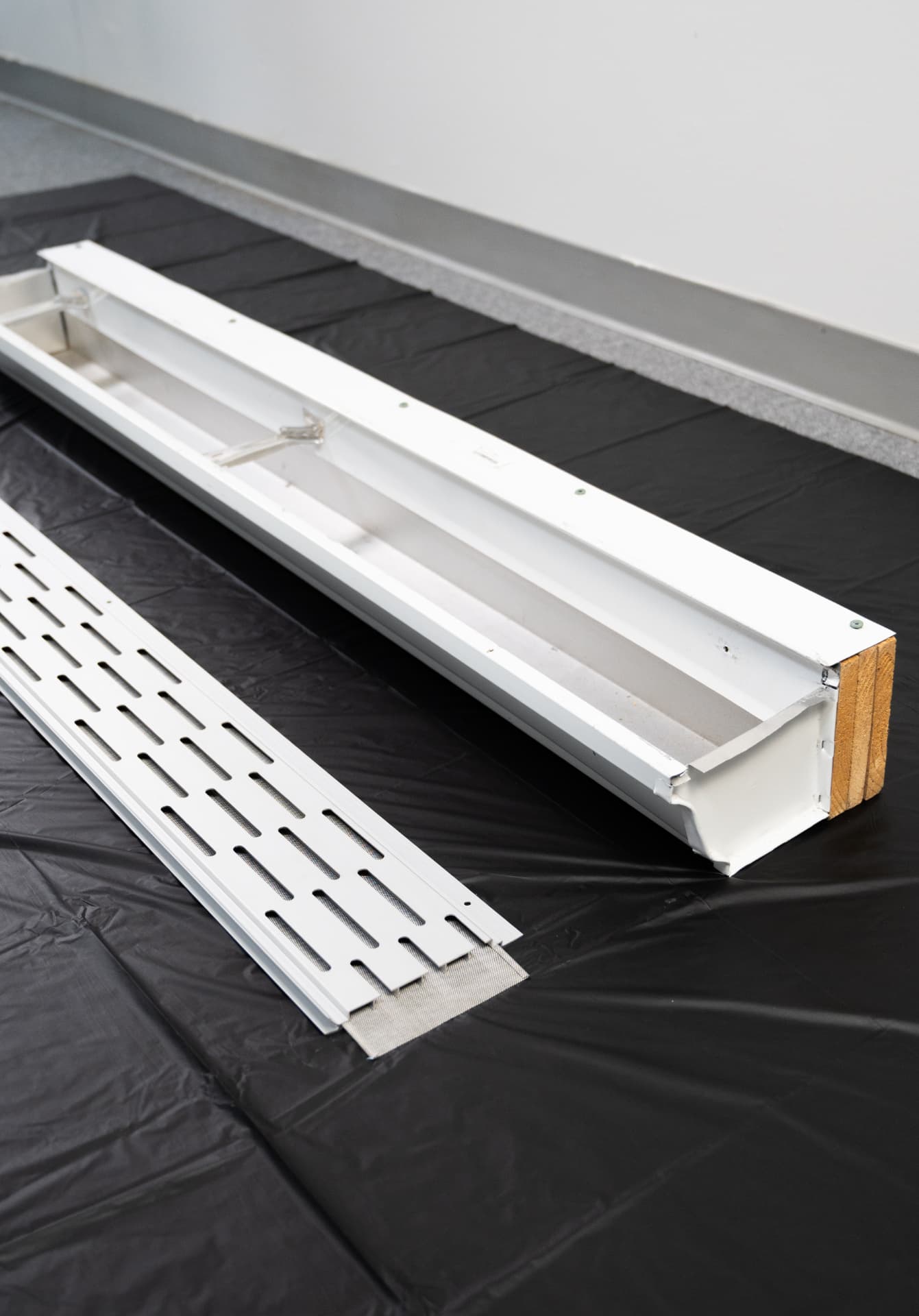 Gutter Goddess guard beside a gutter section, ready to be fitted after cleaning